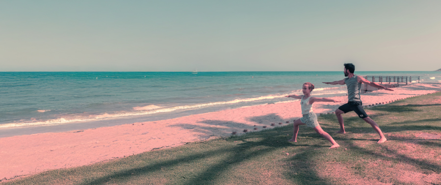 familia haciendo yoga en la playa